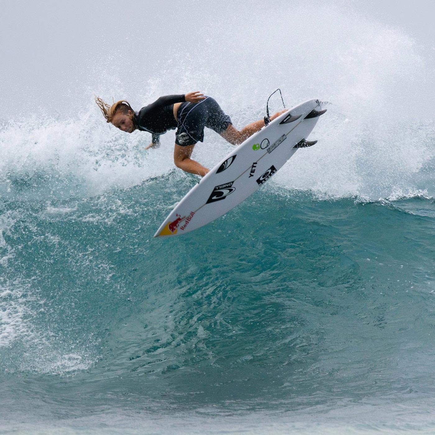 Surfer performing a trick on a wave with a surfboard
