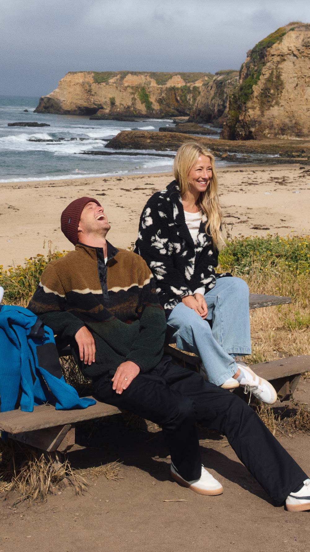 Man and woman sitting on a bench at the beach