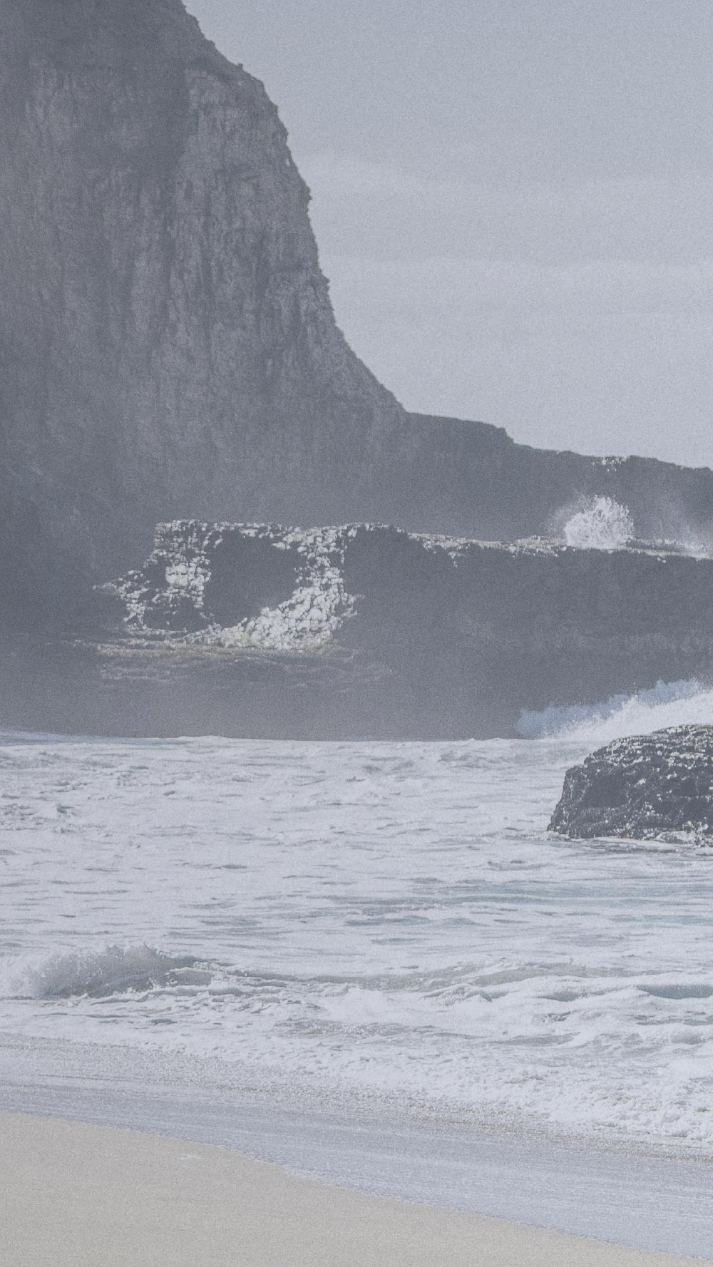 Wave crashing against a cliff on a beach