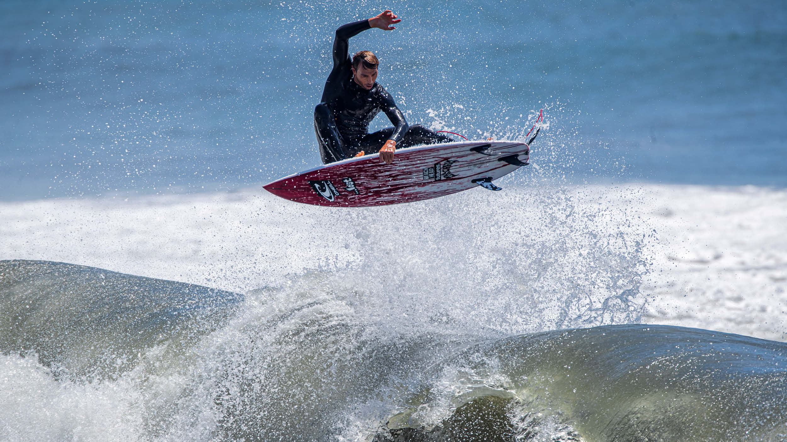 Surfer in action on a wave with a clear sky background