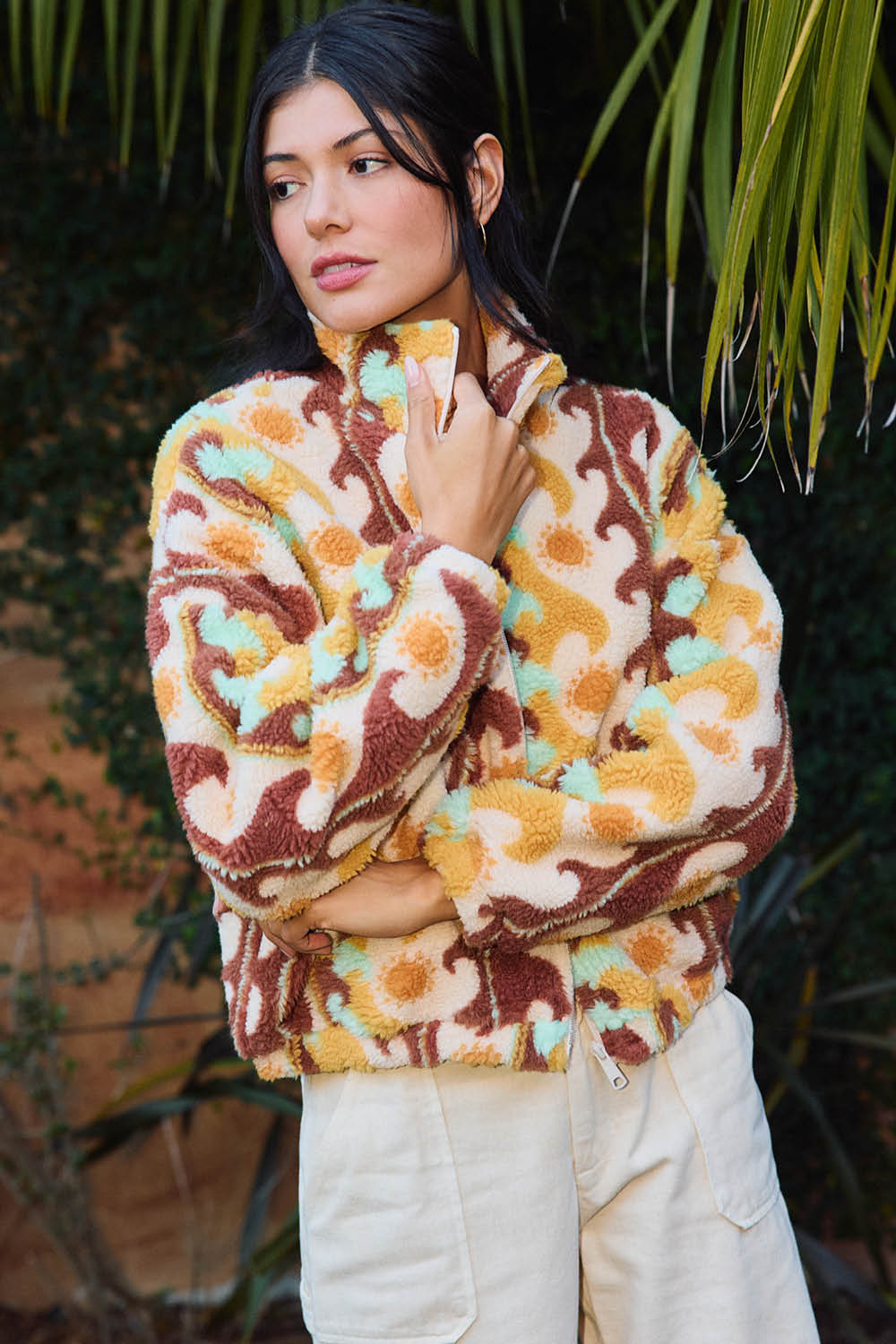 Woman wearing a patterned sweater with a blurred natural background